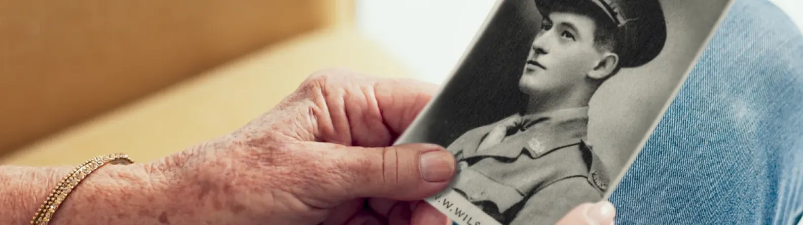 Close-up of a hand holding a black and white picture of a soldier