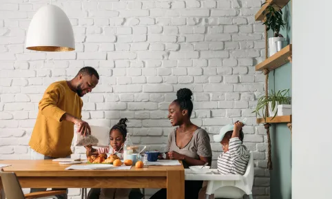 A family gathered around a dining table in their home enjoying a meal together.