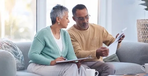 Couple sitting together looking at paperwork 