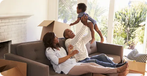 New parents playing with their baby inside their new home.