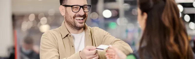 Man handing bank card to bank customer service representative