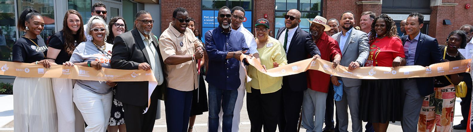 A group of people celebrating at a ribbon cutting