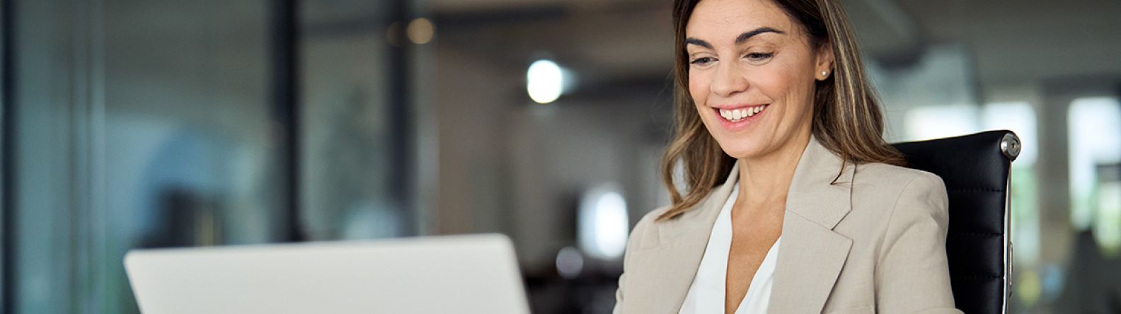 A woman smiling at a laptop