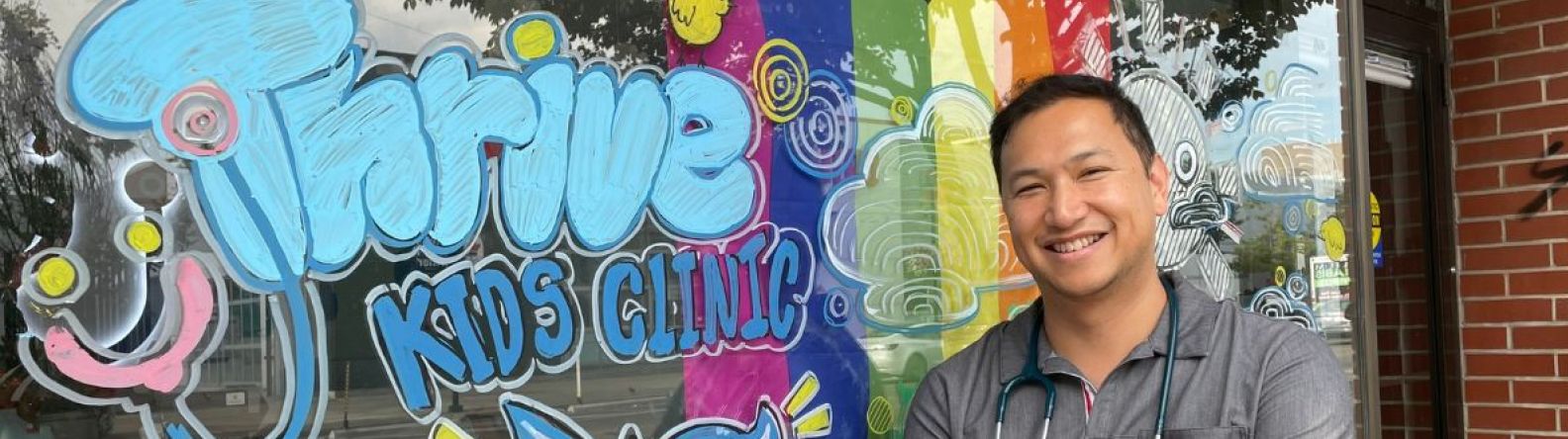 Médecin debout devant une fenêtre décorée de couleurs vives