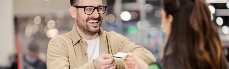 Man handing bank card to bank customer service representative