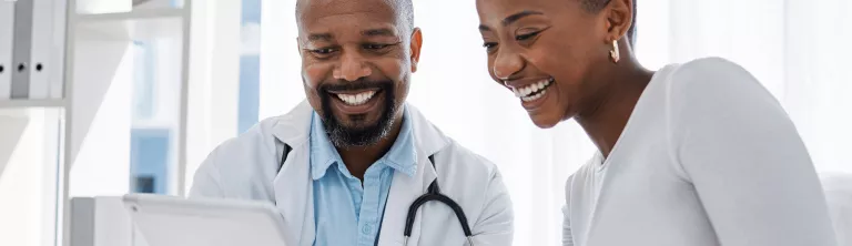 Doctor and patience looking at a screen tablet. 