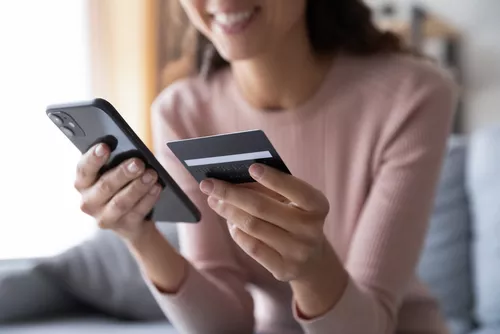 Woman holding her phone and credit card